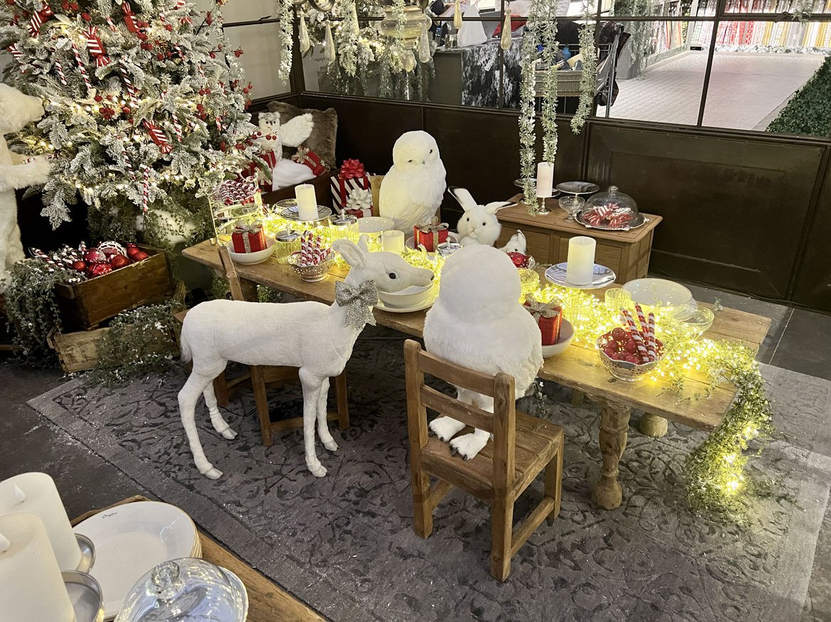 Table festive avec invités de la forêt - Sapin rouge et blanc & guirlandes lumineuse - Schilliger